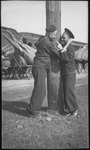 Two sailors hugging around a telephone pole