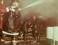 Firefighters spraying water on fire