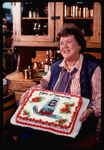Julia Child holds cake commemorating 10th anniversary of KUHT Channel 8's Auction