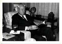W. B. Bates sitting with a book in hand