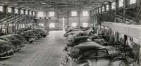Men working on vehicles inside a repair facility