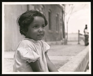 Young girl sitting on curb during filming of documentary about the foundation of the Chamizal National Memorial