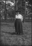 Woman facing camera in a wooded area