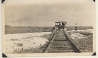 Three men observing steam road tracks between Texas City and La Marque