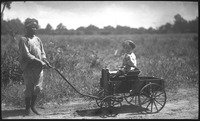 Boy pulling small child in wagon