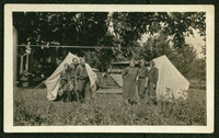 Men and women in front of tents