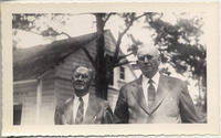 Two men standing in front of house