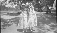 Two girls smiling in white dresses