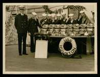 Crew members with Christmas fruitcake given to them by the Cruiser Houston Committee