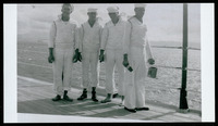 Four crew members standing, one with paint and paintbrush