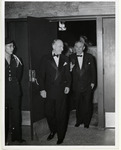 Hugh Roy Cullen in formal attire exiting a doorway