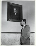 Roy G. Cullen standing beneath his portrait