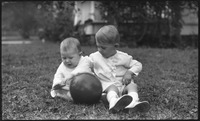 Two young children playing with a ball