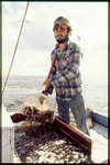 A shrimper holding a net with shrimp