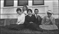 Group of adults and a child sitting on grass