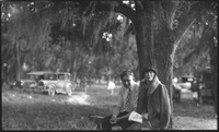 Man and woman sitting under tree