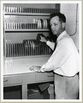 Dr. John Meaney in front of a collection of film reels