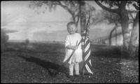 Child holding American flag and toy gun